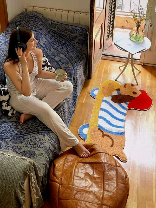 Alfombra Poppi en un dormitorio, junto a una cama — referencia de tamaño real.